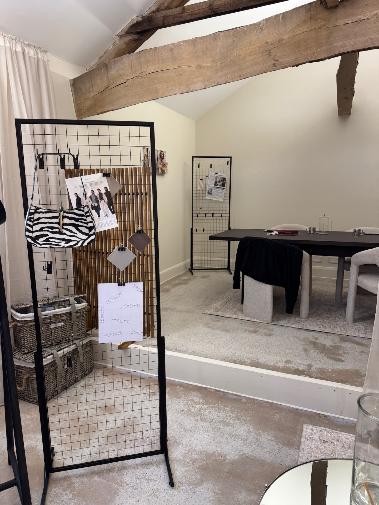 The Mondays moodboard with a zebra-print handbag, magazine clippings and fabric swatches at the boardroom table